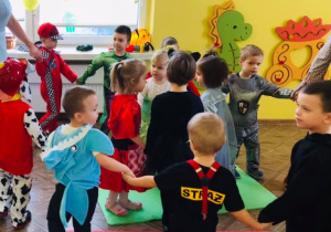 dzieci tańczą trzymając się za ręce tworząc węża