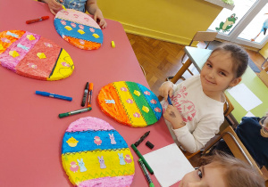 Dzieci wyklejają wielkie pisanki ze styropianu
